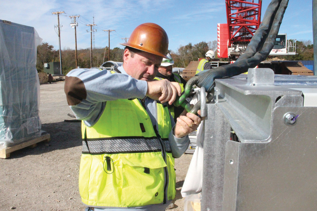 ON THE JOB: Mark DePasquale affixes a shackle before a crane lifts instrumentation panels into place.